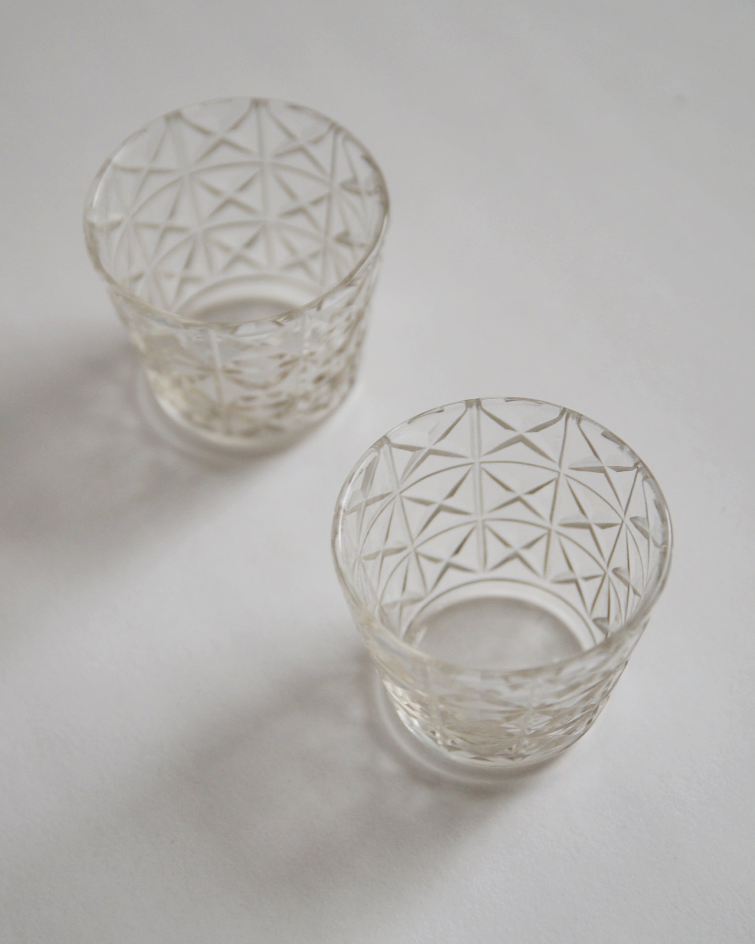Two mini choko crystal cut glasses diagonally placed.
