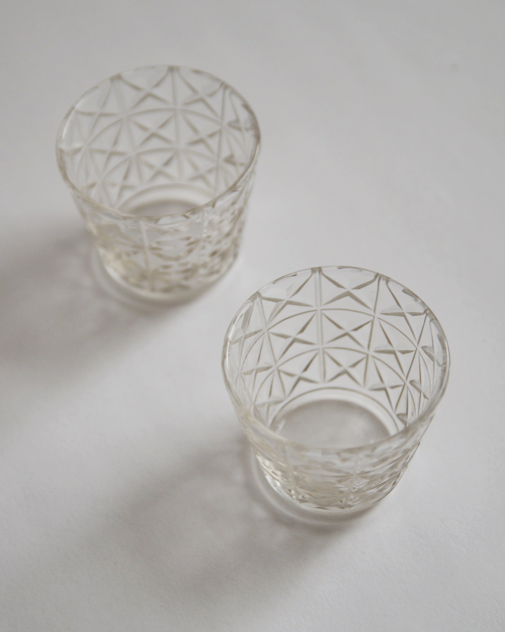 Two mini choko crystal cut glasses diagonally placed.