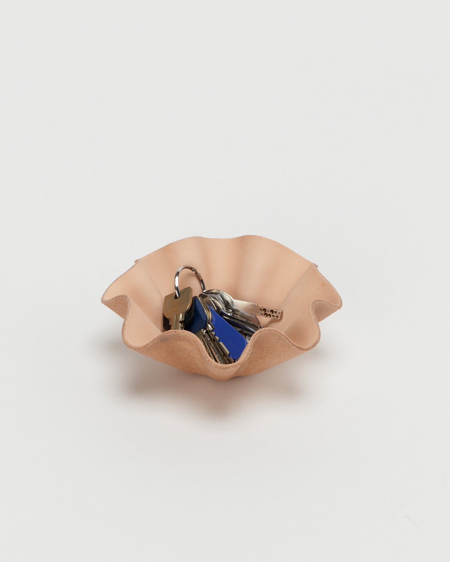Leather Shell Bowl by Hender Scheme in small  with keys in bowl on a gray  background