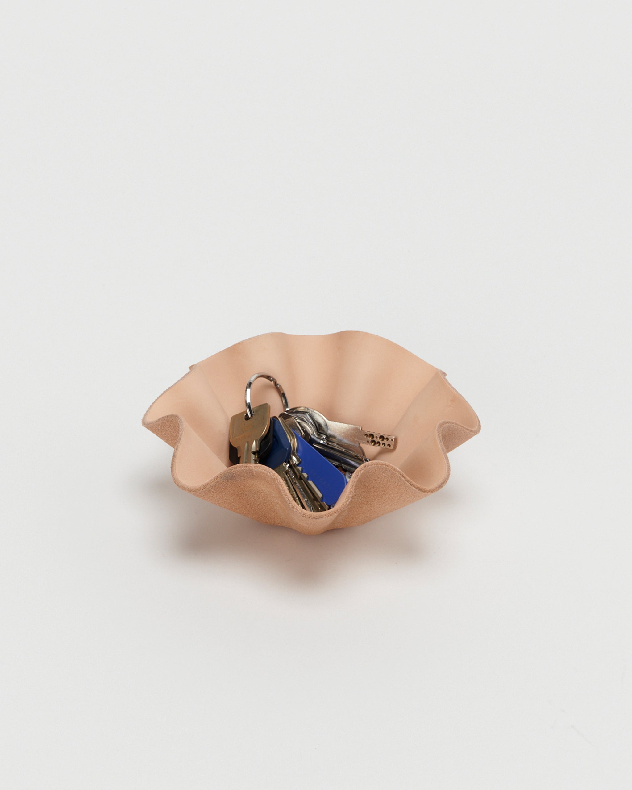 Leather Shell Bowl by Hender Scheme in small  with keys in bowl on a gray  background