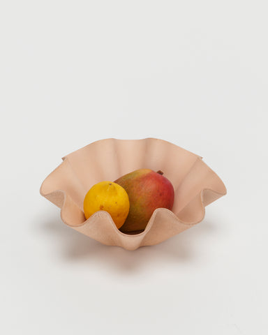Leather Shell Bowl by Hender Scheme in large with fruits in the bowl on a gray background
