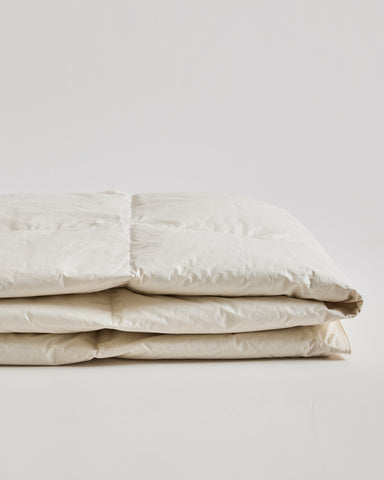Up-close Folded Light Duvet by Iwata on a gray background