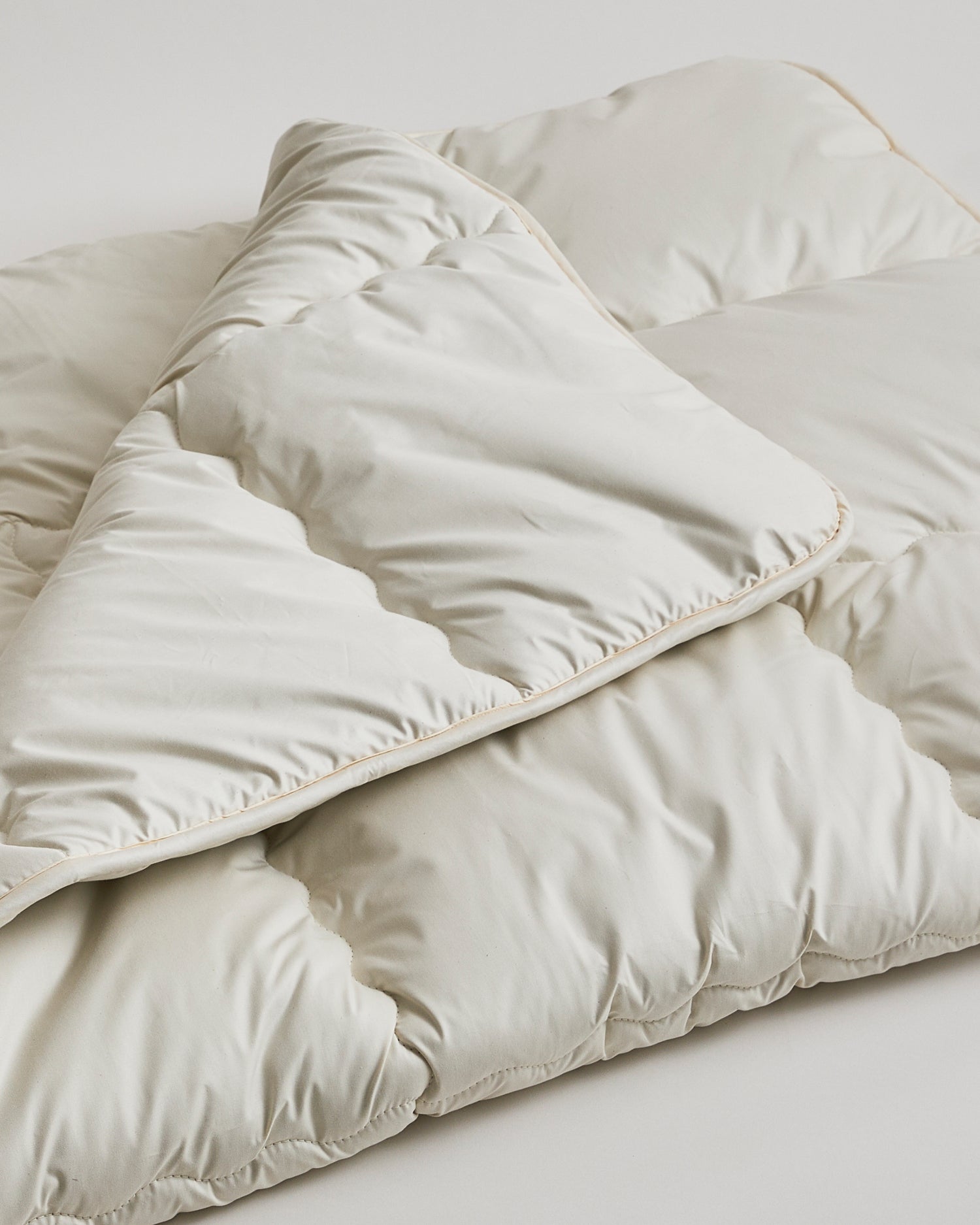 Up-Close of Camel Heavy Mattress Pad by Iwata on a gray background