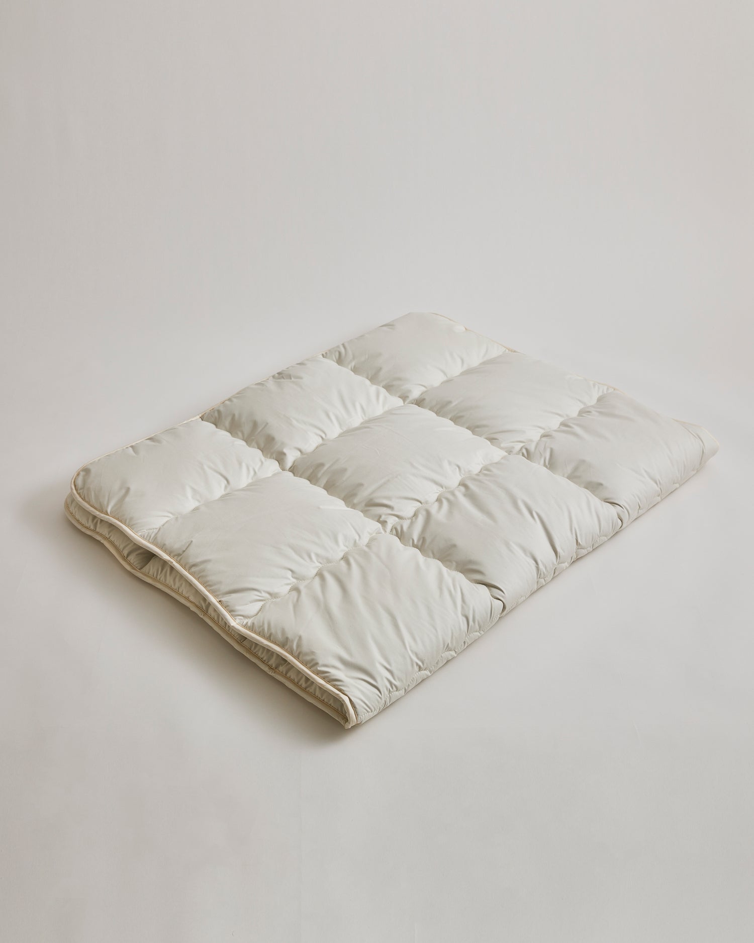 Camel Heavy Mattress Pad by Iwata on a gray background