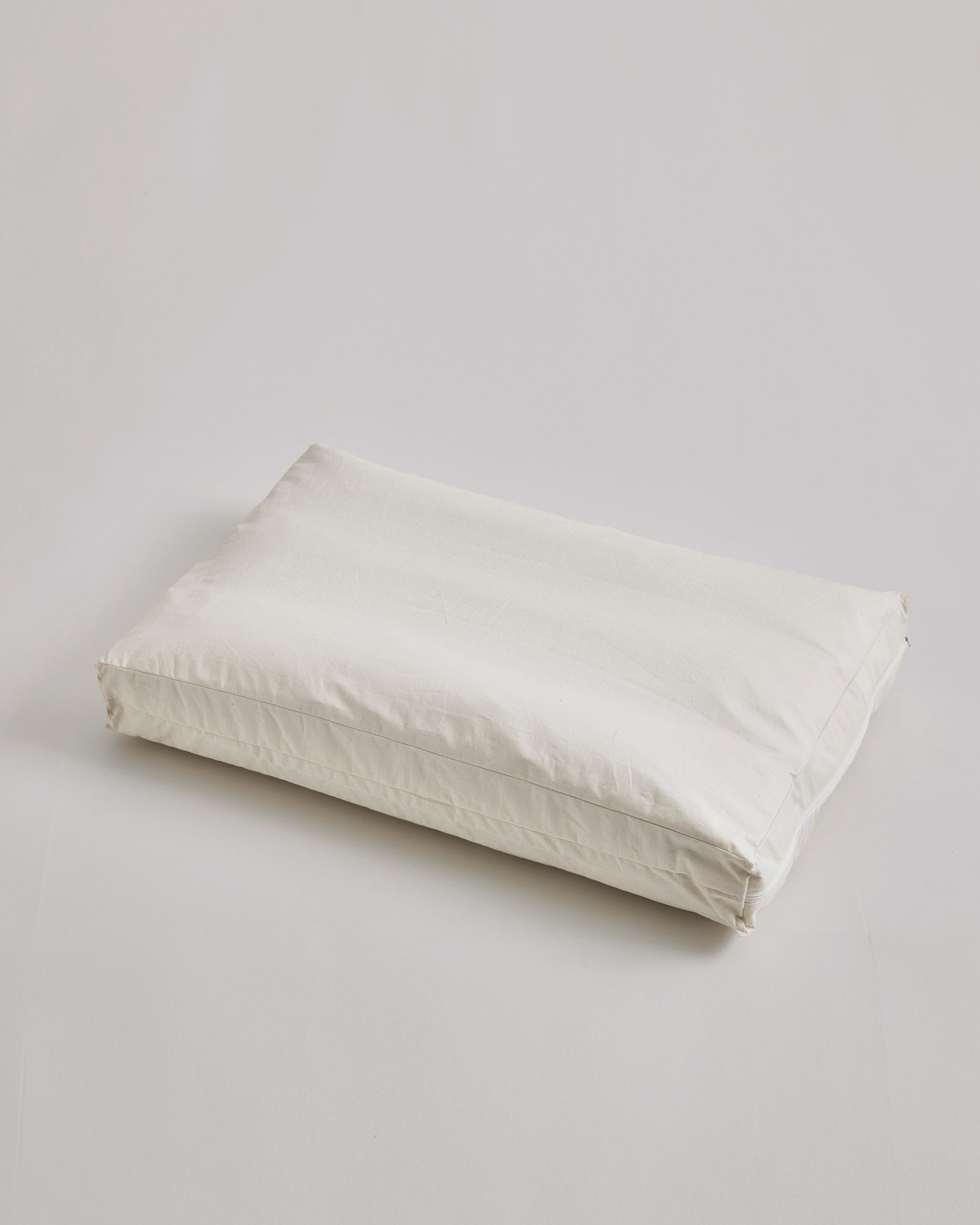 CAmel hair pillow by Iwata on a light gray background