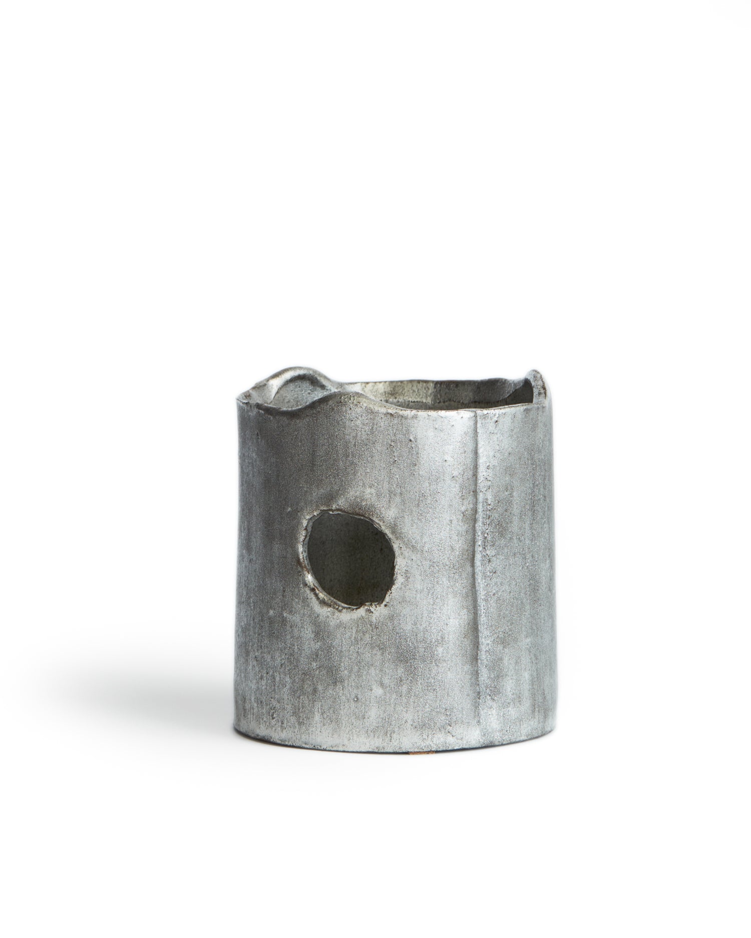 Silhouetted image of ceramic teapot warmer with sterling silver overglaze by Masanobu Ando against white background.