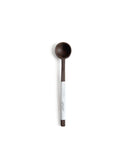 Silhouetted image of hand carved tagaya wood spoon with label by Nalata Nalata against white background.