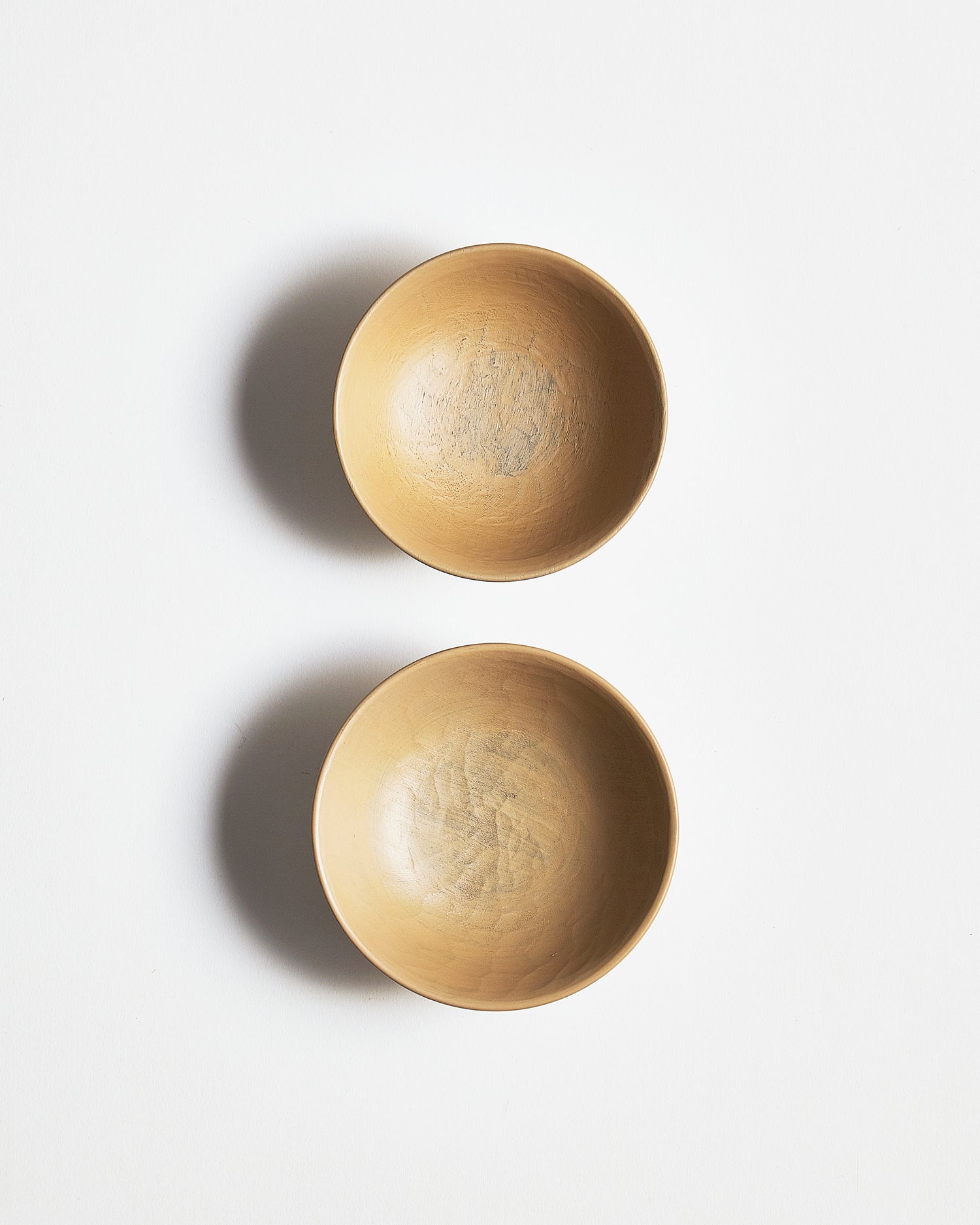 Top view of White Urushi Baby Bowl Set, vertically side-by-side, by Ryuji Mitani against white-gray background.