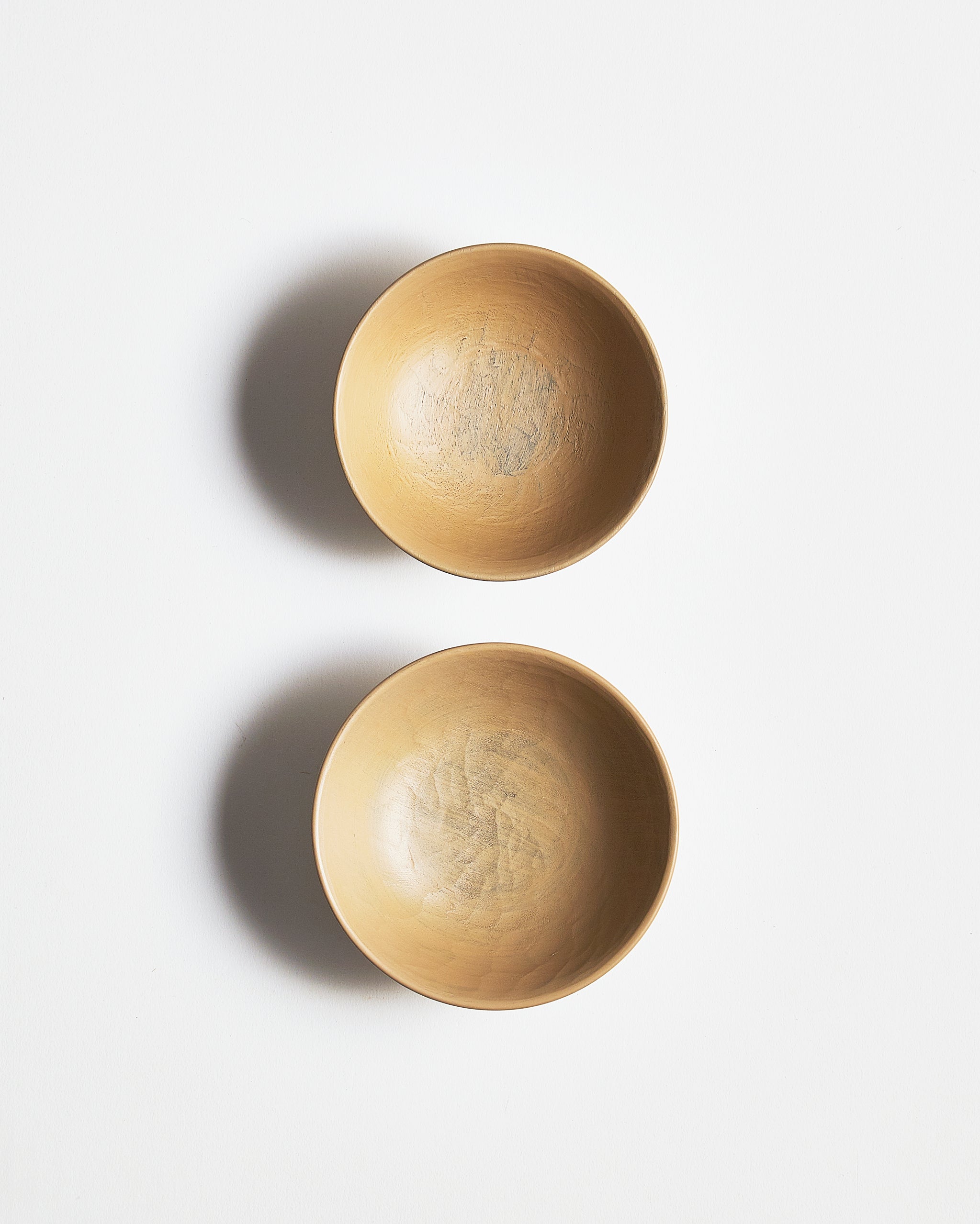 Top view of White Urushi Baby Bowl Set, vertically side-by-side, by Ryuji Mitani against white-gray background.