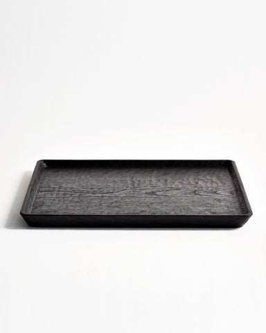 Front view of Carved Noir Wood Tray with Enju Wood by Ryuji Mitani against white-gray background.