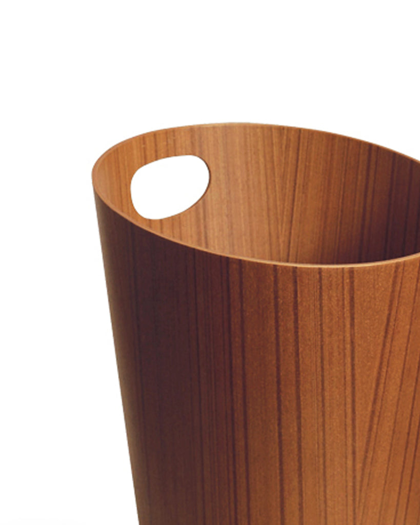 Cropped image focused on handle of teak paper waste basket with handle by Isamu Saito against white background.