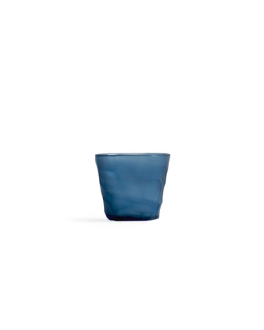 Silhouetted dark blue reclaimed blue mini choko glass in rock pattern, against white background.