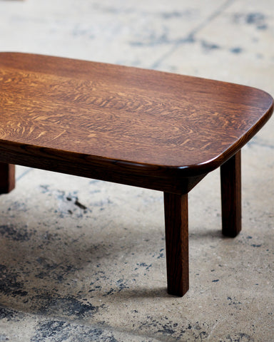 Cropped detail view of the chabudai table, placed on a textured cement floor.