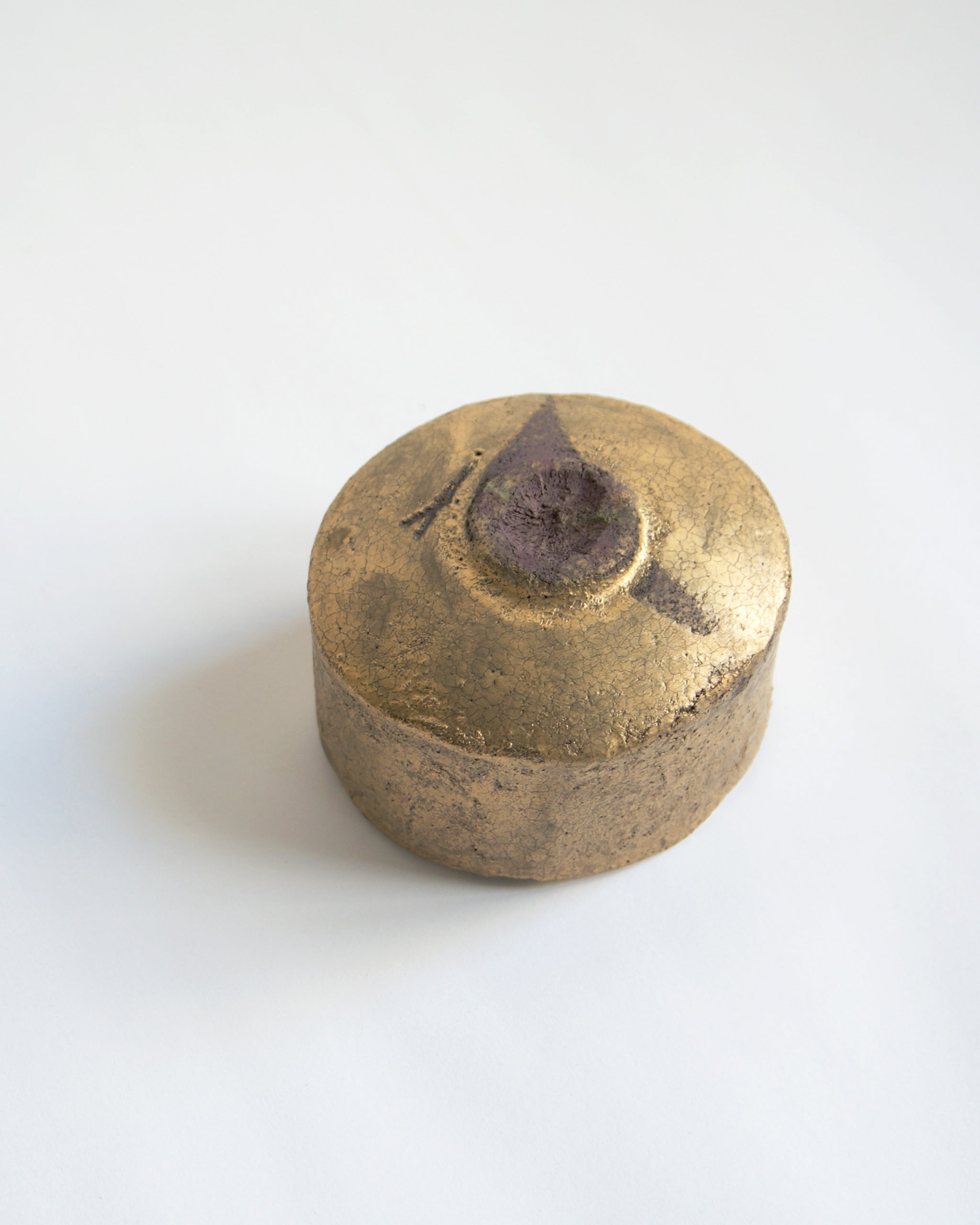 Upside down Gold Chawan XIII against gray background.