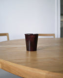 Red urushi wood cup on an oak wood dining table
